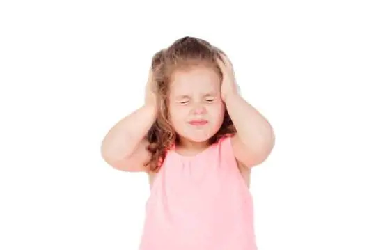 A little girl closes off her ears and shuts her eyes to not hear and listen anything while she throws a tantrum