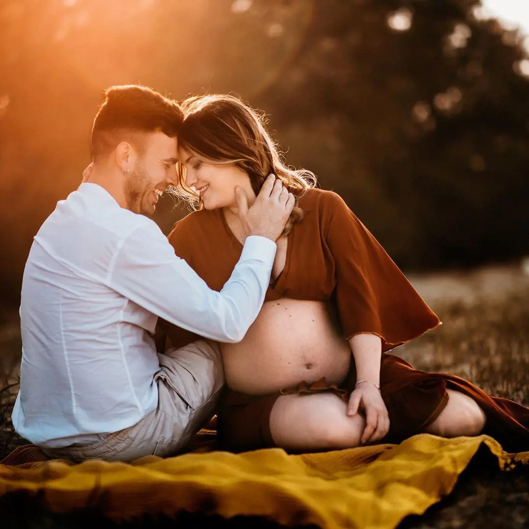 A man embraces his pregnant partner during sunset and the moment is captured by Rossella Inguscio